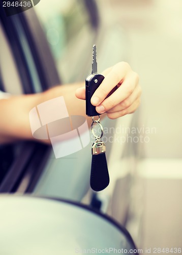 Image of man with car key outside