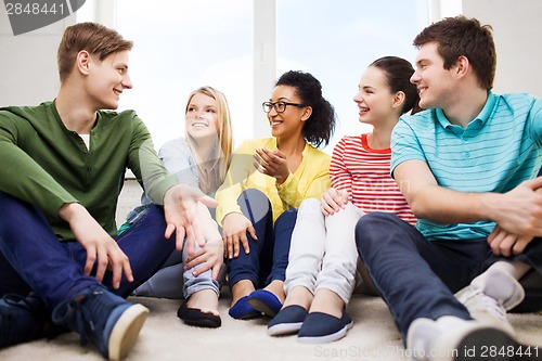 Image of five smiling teenagers having fun at home