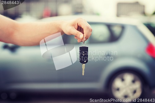 Image of man with car key outside