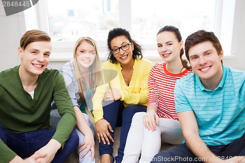 Image of five smiling teenagers having fun at home