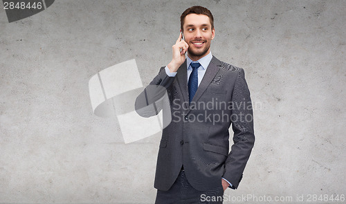 Image of young smiling businessman with smartphone