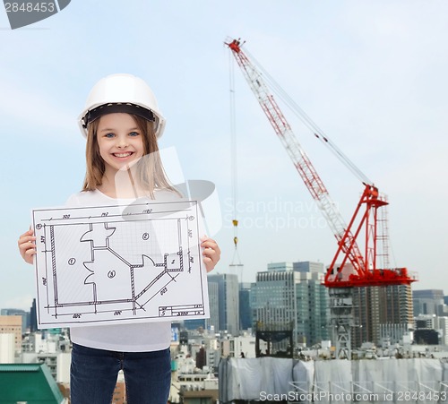 Image of smiling little girl in helmet showing blueprint