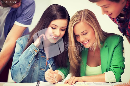 Image of students pointing at notebook at school