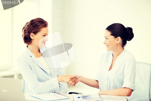 Image of businesswomen shaking hands in office