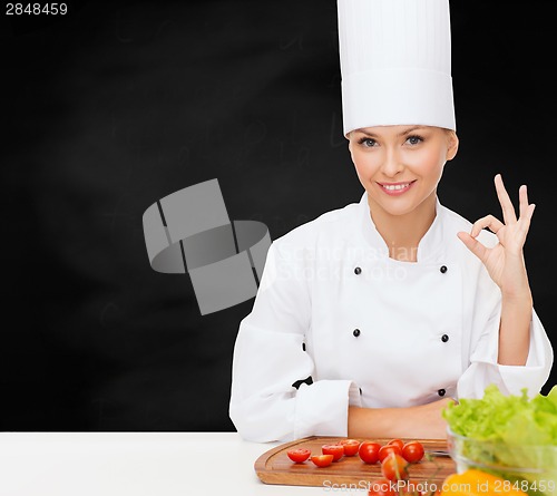 Image of female chef with vegetables showing ok sign