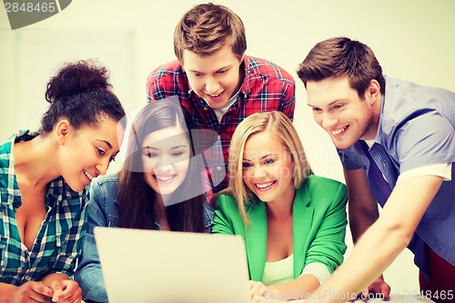 Image of international students looking at laptop at school