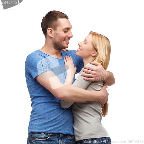 Image of smiling couple hugging and looking at each other