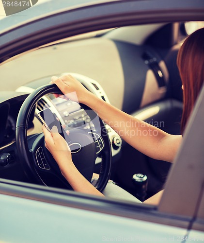 Image of woman using phone while driving the car