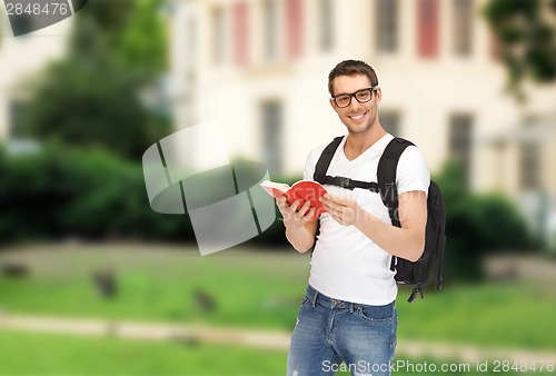 Image of travelling student with backpack and book