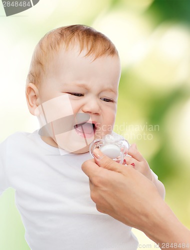 Image of crying baby with dummy