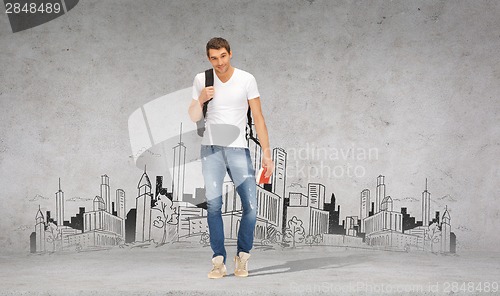 Image of smiling student with backpack and travel guide