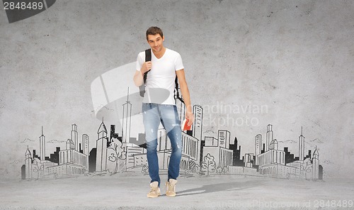 Image of smiling student with backpack and travel guide