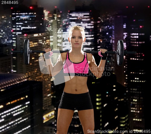 Image of sporty woman exercising with barbell