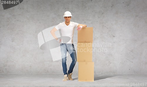 Image of man in helmet with tower of cardboard boxes