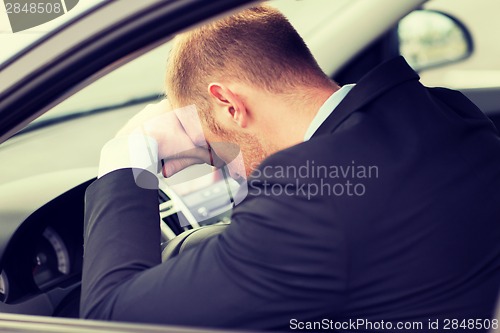 Image of tired businessman or taxi car driver