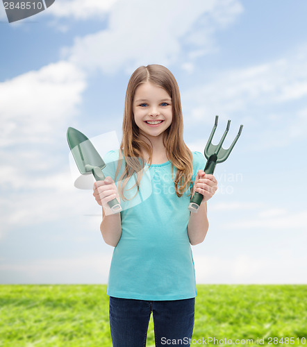 Image of smiling little girl with rake and scoop