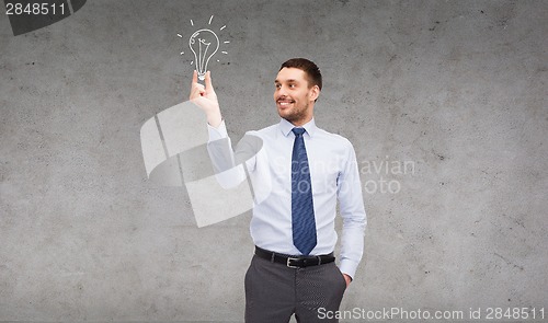 Image of handsome businessman holding light bulb