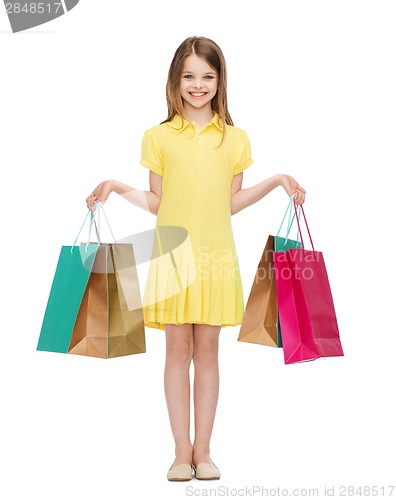 Image of smiling little girl in dress with shopping bags