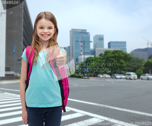 Image of smiling girl with school bag showing thumbs up