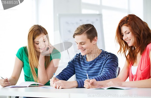 Image of smiling students with textbooks at school