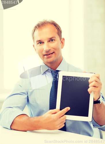 Image of smiling businessman with tablet pc in office