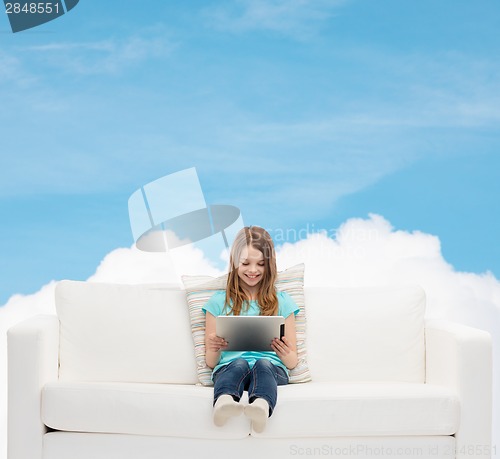 Image of little girl sitting on sofa with tablet pc