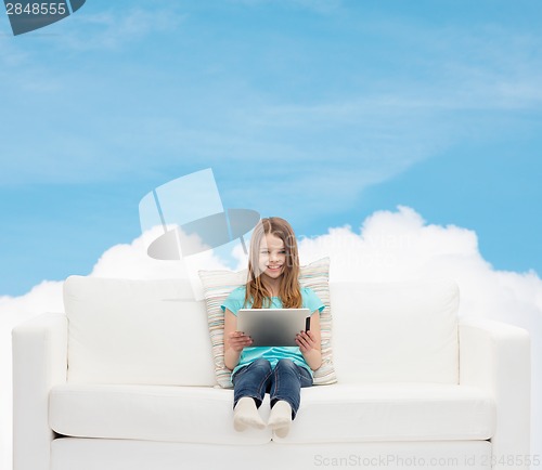 Image of little girl sitting on sofa with tablet pc