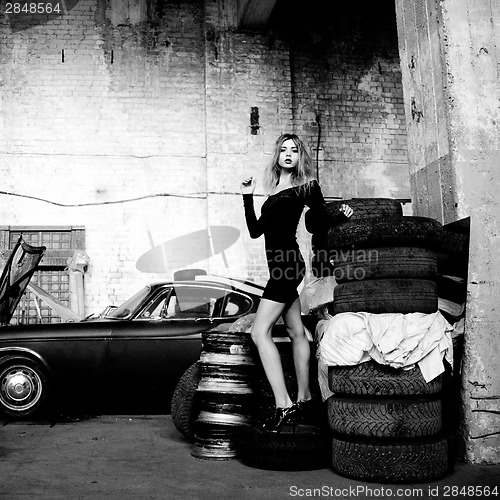 Image of fashionable woman in retro garage