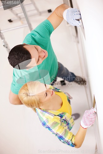 Image of smiling couple doing renovations at home