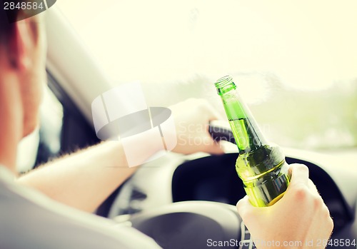 Image of man drinking alcohol while driving the car
