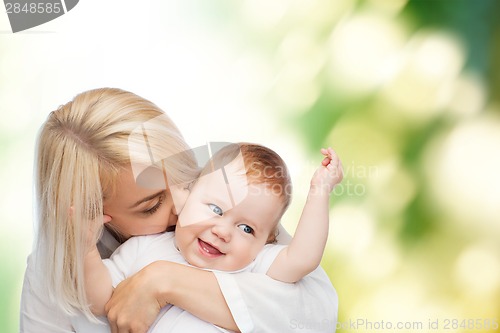 Image of happy mother kissing smiling baby