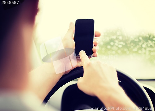 Image of man using phone while driving the car