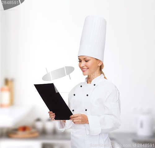 Image of smiling female chef with black blank paper