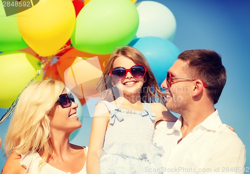 Image of happy family with colorful balloons outdoors
