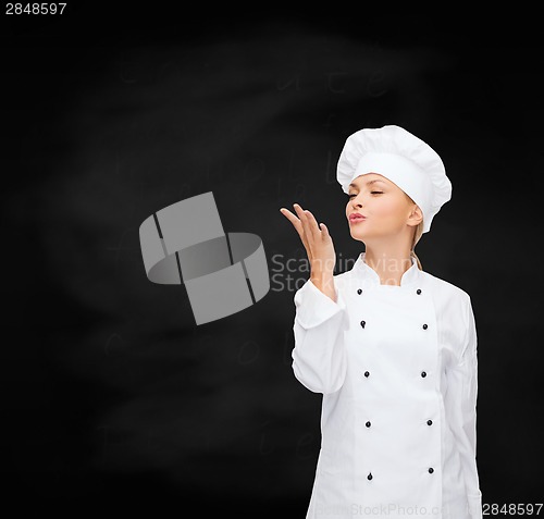 Image of smiling female chef showing delicious sign