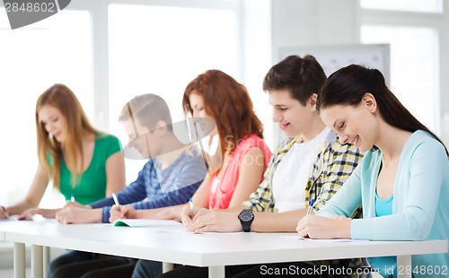 Image of smiling students with textbooks at school