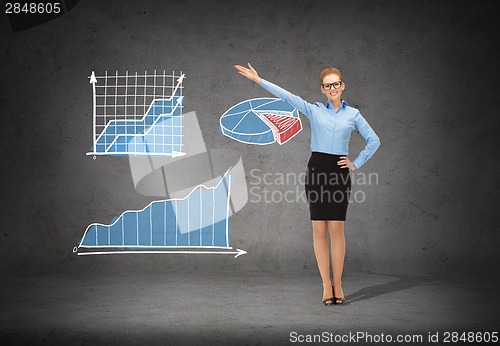 Image of smiling businesswoman in glasses pointing her hand