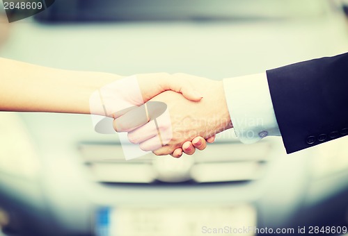 Image of customer and salesman shaking hands