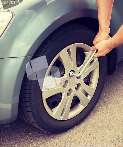 Image of man changing tire