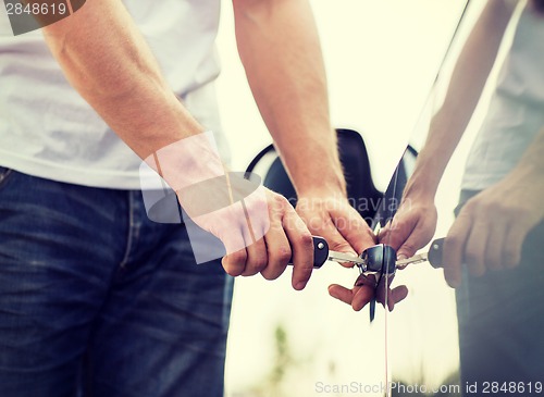 Image of man with car key outside