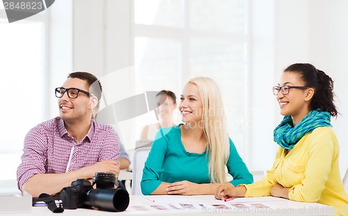 Image of smiling team with photocamera working in office