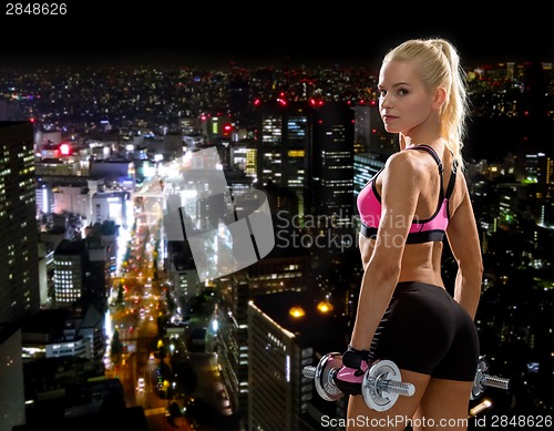 Image of sporty woman with heavy steel dumbbells