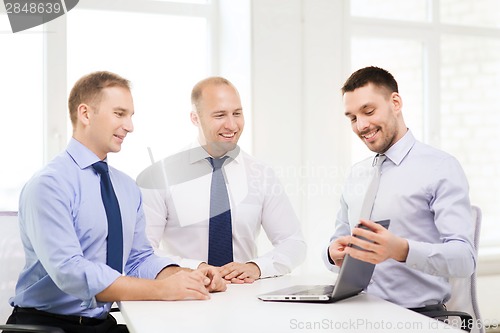 Image of business team working with laptop in office