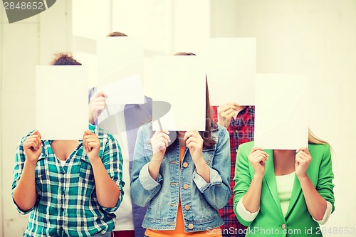 Image of students covering faces with blank papers