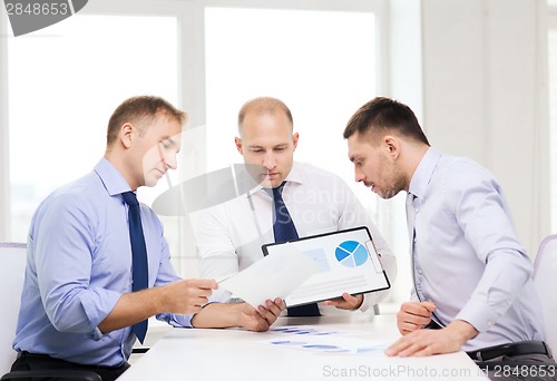 Image of serious businessmen with papers in office