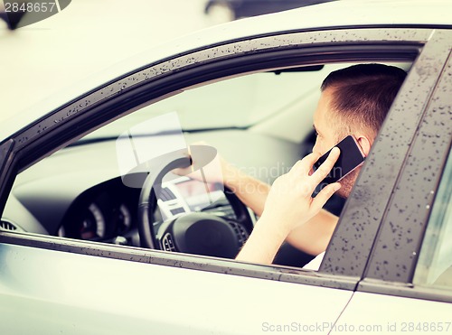 Image of man using phone while driving the car