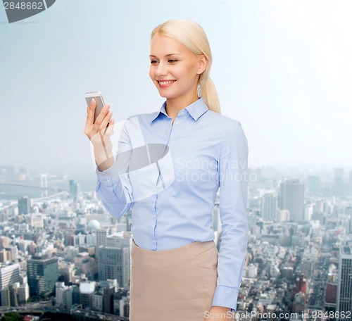 Image of young smiling businesswoman with smartphone