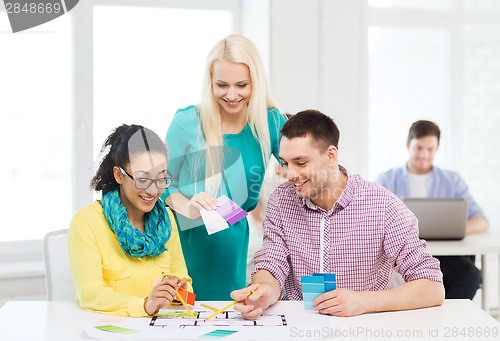 Image of smiling interior designers working in office