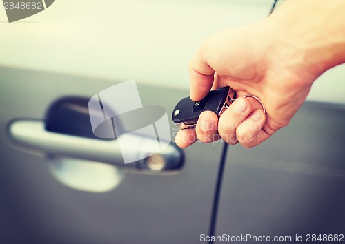 Image of man with car key outside