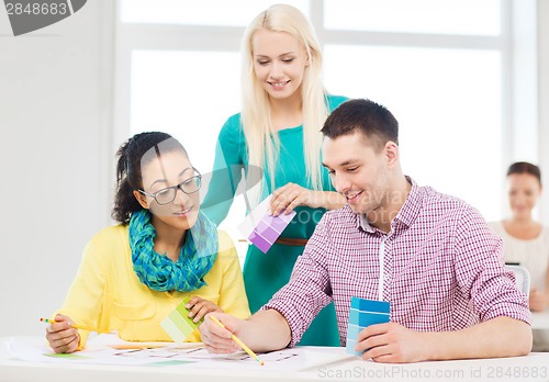 Image of smiling interior designers working in office